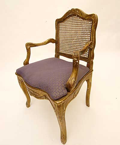 Pair of French, Regence style, carved giltwood and caned fauteuils