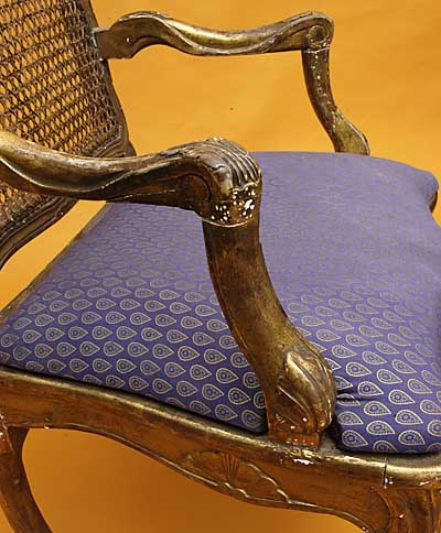 Pair of French, Regence style, carved giltwood and caned fauteuils